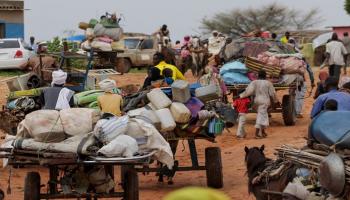 أصحاب عربات ينقلون متعلقات الذين فروا من الصراع في منطقة دارفور بالسودان