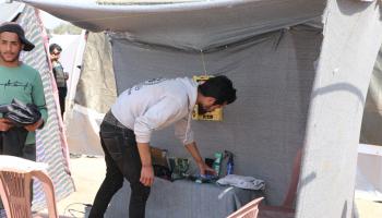 أحمد يرتب أدوات صالونه المتواضع في المخيم