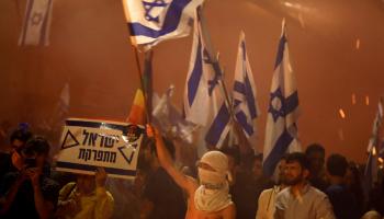 محتجون يرفعون العلم الإسرائيلي خلال مظاهرات الليلة الماضية