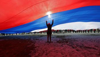 أحد المشاركين في احتفالية بذكرى ضم القرم يقف تحت العلم الروسي