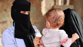 طبيبة تفحص طفلا في اليمن