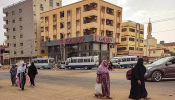 نساء يسرن على طول شارع في جنوب الخرطوم (أ ف ب)