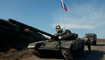 دبابة ترفع العلم الروسي خلفها حاملة جند - رويترز
