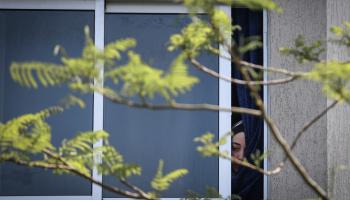  فلسطينية تشاهد من نافذتها جنازة ضحايا العملية الإسرائيلية