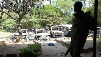 شرطي كيني أمام مركبات محترقة في هجوم لحركة الشباب- أرشيفية