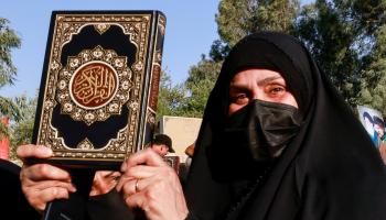 امرأة ترفع القرآن أمام سفارة السويد ببغداد