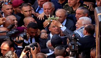 الرئيس الفلسطيني متشحا بالكوفية وممسكا بغصن الزيتون خلال زيارة جنين