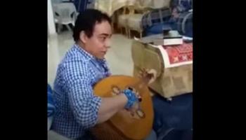 شخص يقرأة القرآن على آلة العود 