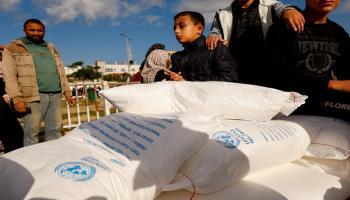 فلسطينيون يتلقون أكياس الطحين التي وزعتها الأونروا في رفح بجنوب قطاع غزة