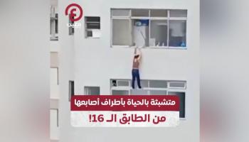 امرأة تعلق بحافة مبنى شاهق