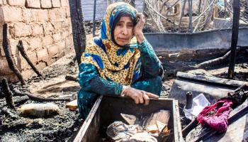 يمنية تتوسط آثار حريق منزلها