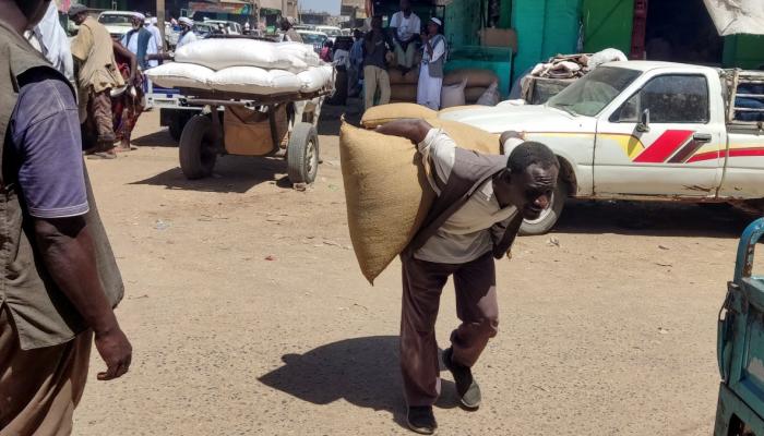سوداني ينقل بعض المحصول على ظهره - AFP