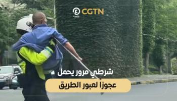 شرطي مرور يحمل عجوزاً لعبور الطريق