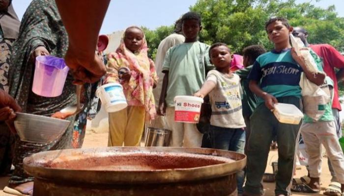 أطفال سودانيون ينتظرون توزيع الطعام عليهم