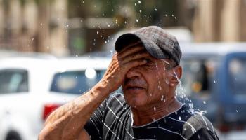 رجل يواجه ارتفاع درجات الحرارة بالماء- أرشيفية