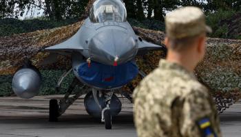 جندي أوكراني يقف بجوار طائرة من طراز F-16