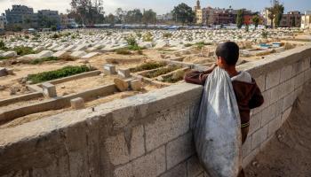 طفل فلسطيني ينظر إلى مقبرة في غزة