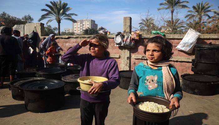 فلسطينيون يتلقون مساعدات غذائية يجري توزيعها في دير البلح