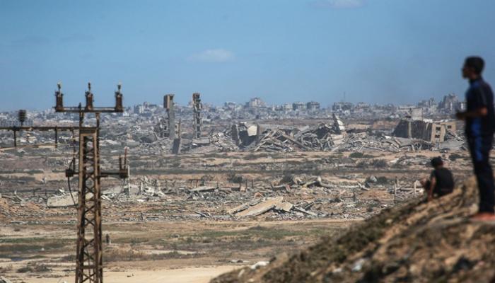 فلسطينيون يشاهدون تصاعد الدخان جراء الغارات الإسرائيلية على مخيم النصيرات 