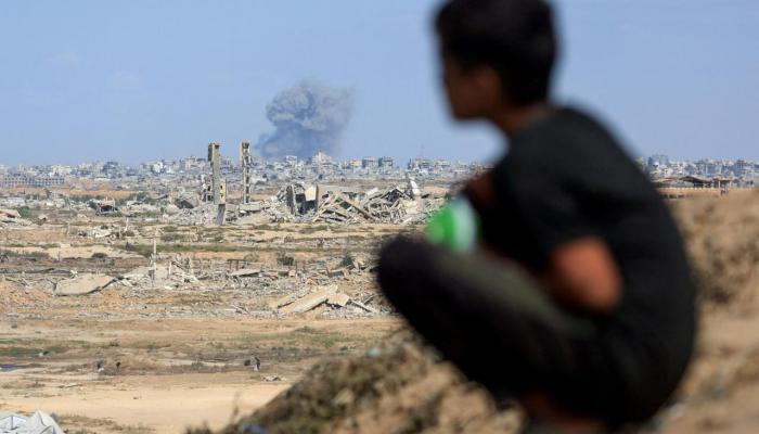 طفل فلسطيني ينظر إلى غارة إسرائيلية في غزة- أرشيفية