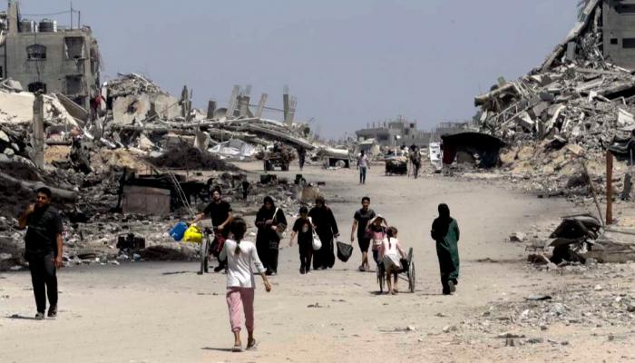 فلسطينيون وسط الدمار بغزة