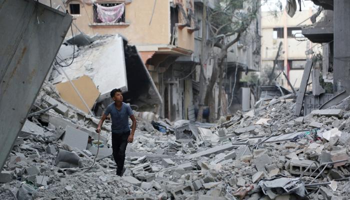 طفل فلسطيني أمام منازل مدمرة بغزة