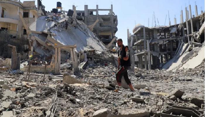 فلسطيني يسير وسط الأنقاض في غزة