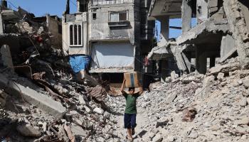 طفل يحمل كرتونة مساعدات في غزة