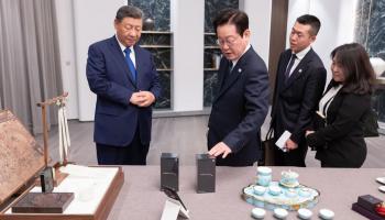 لحظة تقديم شي الهاتفين إلى نظيره الكوري