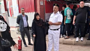رجال شرطة يساعدون كبار السن للإدلاء بأصواتهم في الانتخابات