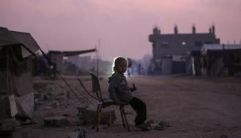 طفلة فلسطينية نازحة تجلس خارج ملجأ في مخيم البريج للاجئين
