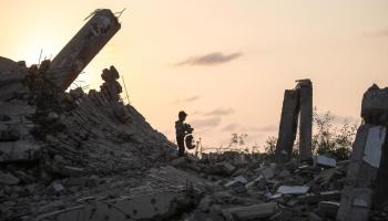 طفل فلسطيني يقف على ركام منزل عائلته في غزة