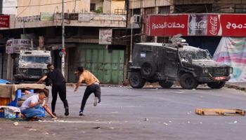 فلسطينيان يتصديان بالحجارة لقوات إسرائيلية- أرشيفية 