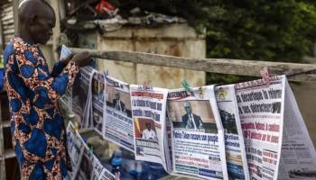 بائع يرتب الصحف على كشك في كوتونو