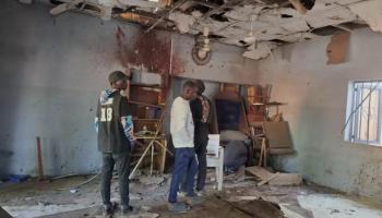 أشخاص يتفقذون موقع التفجير بالمسجد