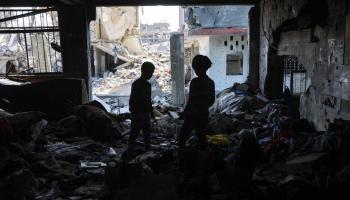 أطفال يتفقدون الأضرار بمبنى في غزة