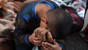 طفل يبكي فراق أحد أفراد عائلته جراء القصف في غزة