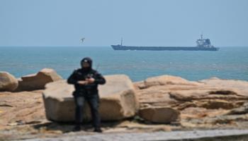 حارس يقف بينما تبحر سفينة شحن بجوار جزيرة بينجتان قرب تايوان