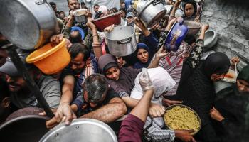 فلسطينيون، معظمهم أطفال، ينتظرون في طوابير طويلة للحصول على مساعدات غذائية