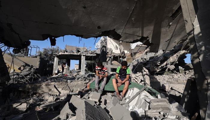 طفلان فلسطينيان يجلسان على أنقاض منزل