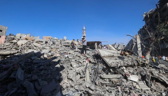فلسطينيون يتفقدون أنقاض منزل تضرر جراء غارة إسرائيلية على مخيم البريج وسط غزة