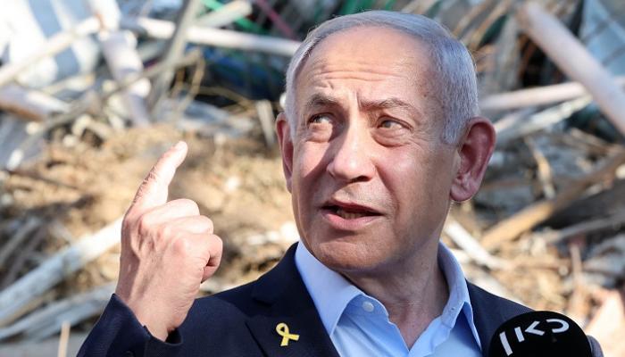 نتنياهو يتحدث وخلفه مبنى مدمر جراء القصف الإيراني