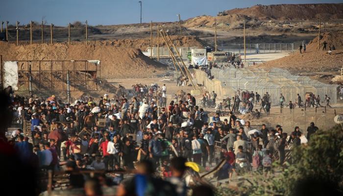 فلسطينيون يتجمعون عند نقطة توزيع مساعدات في وسط قطاع غزة