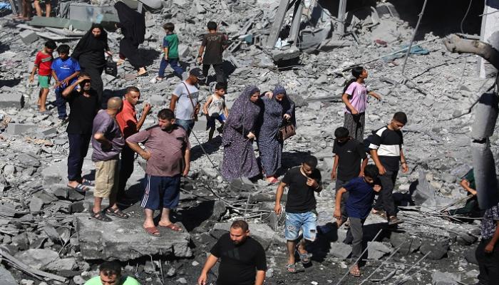 فلسطينيون يتفقدون الأضرار التي لحقت بمخيم البريج وسط قطاع غزة