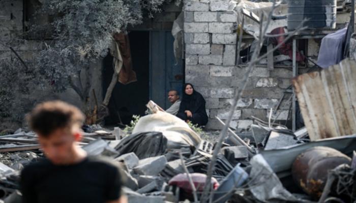 فلسطينيون فوق أنقاض منزل مدمر