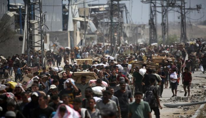 فلسطينيون يعودون إلى مخيم النصيرات من نقطة توزيع مساعدات
