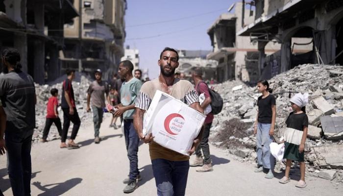فلسطيني في غزة يحمل مساعدات إماراتية
