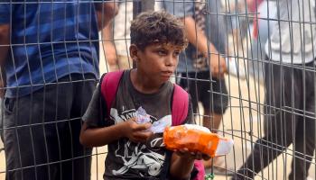 طفل فلسطيني يحمل كيسا من الطحين في غزة - أ.ف.ب