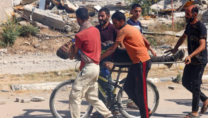 فلسطينيون يحملون جثمان قتيل على دراجة