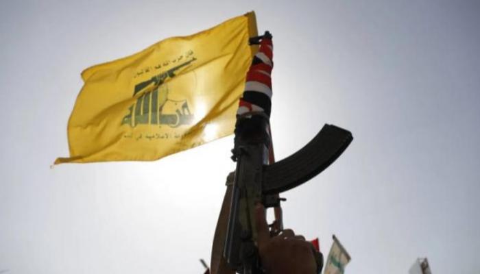 مسلح من حزب الله يحمل شعار التنظيم على بندقية